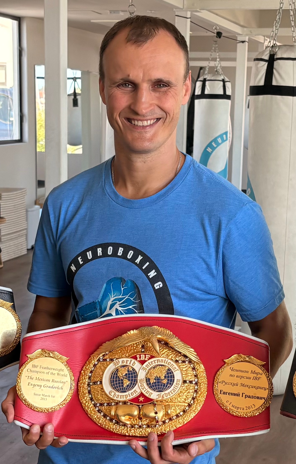 Evgeny Gradovich, IBF Featherweight World Champion, holding his championship belt.