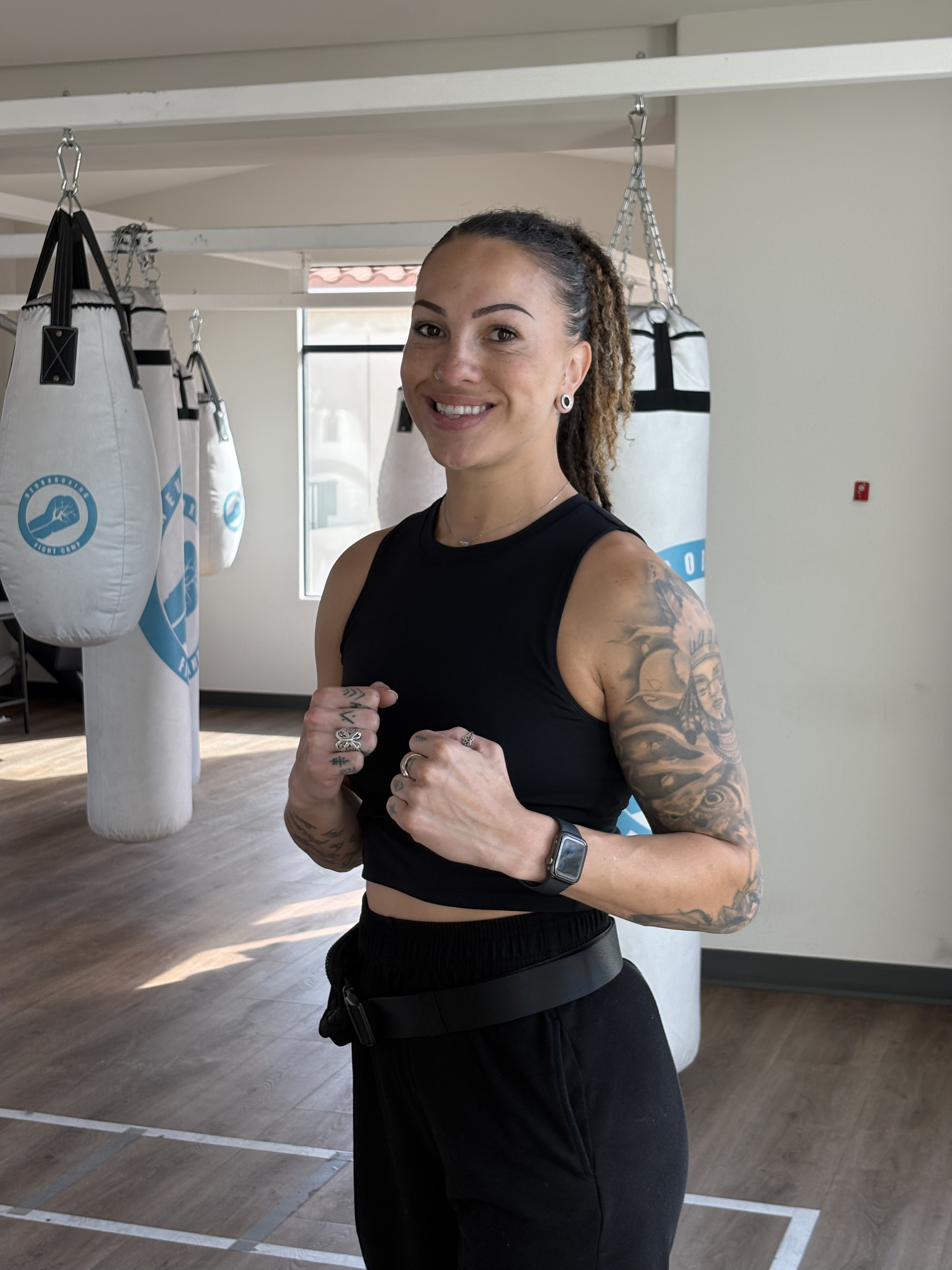 A Portside Fitness coach in the studio in front of Neuroboxing fight camp heavy bags.